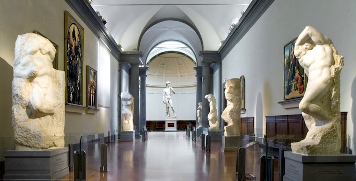 Visitors at Florence's Accademia Gallery viewing Michelangelo's David statue.