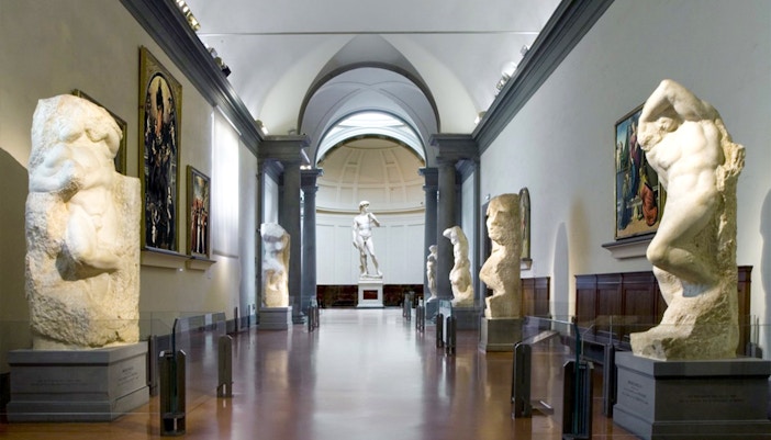 Visitors at Florence's Accademia Gallery viewing Michelangelo's David statue.