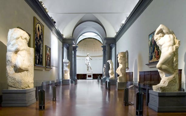 Visitors at Florence's Accademia Gallery viewing Michelangelo's David statue.