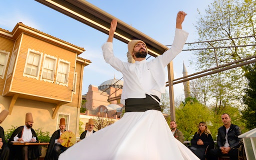 Whirling dervish performing with Hagia Sophia in the background, Istanbul.