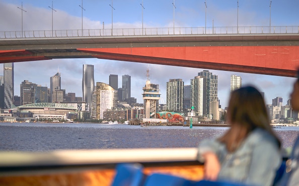 Melbourne skyline viewed from a river cruise under a bridge.