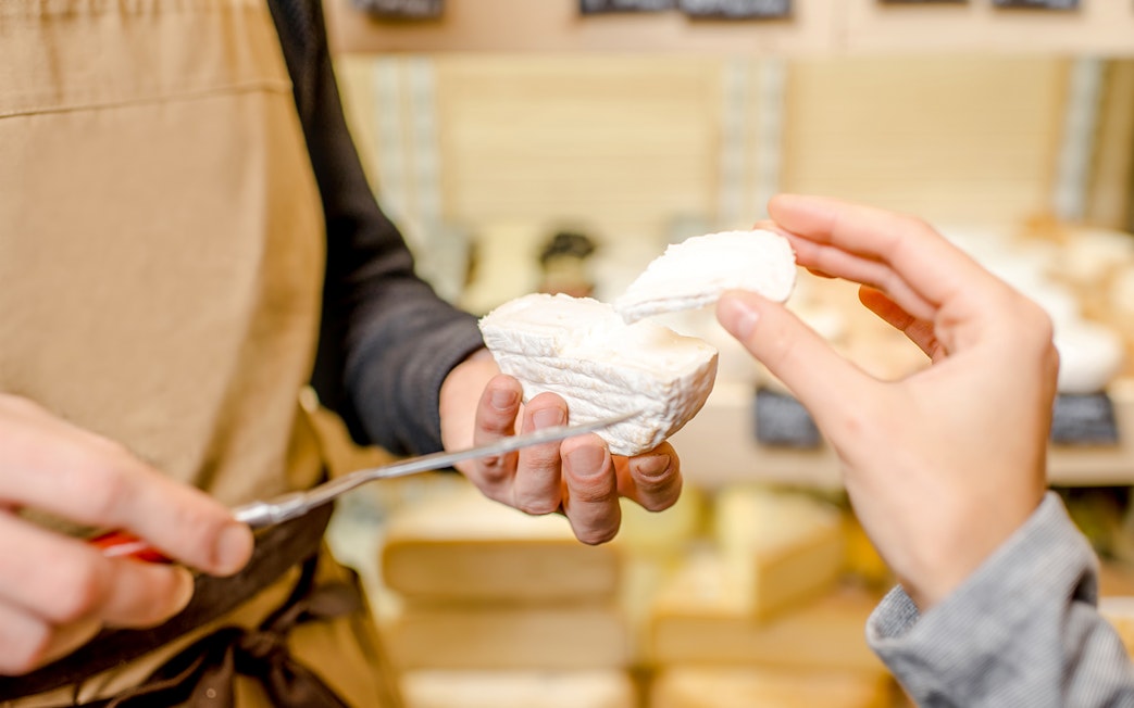 Woman sampling cheese at Cheese Museum in Paris.