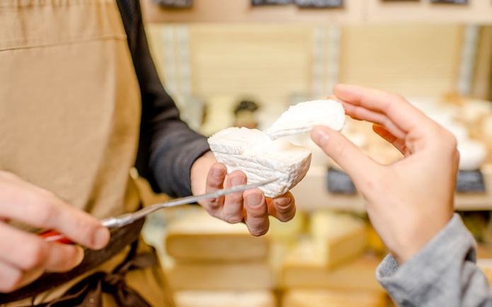 Woman sampling cheese at Cheese Museum in Paris.