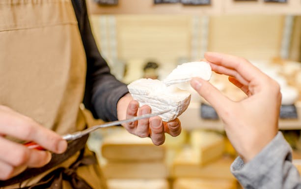 Woman sampling cheese at Cheese Museum in Paris.