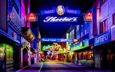 Neon-lit street in St. Pauli, Hamburg, featuring bars and clubs for the Sex & Crime Tour.