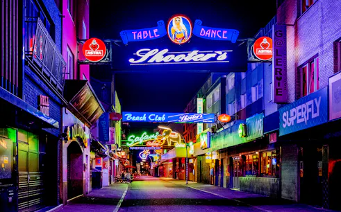 Neon-lit street in St. Pauli, Hamburg, featuring bars and clubs for the Sex & Crime Tour.