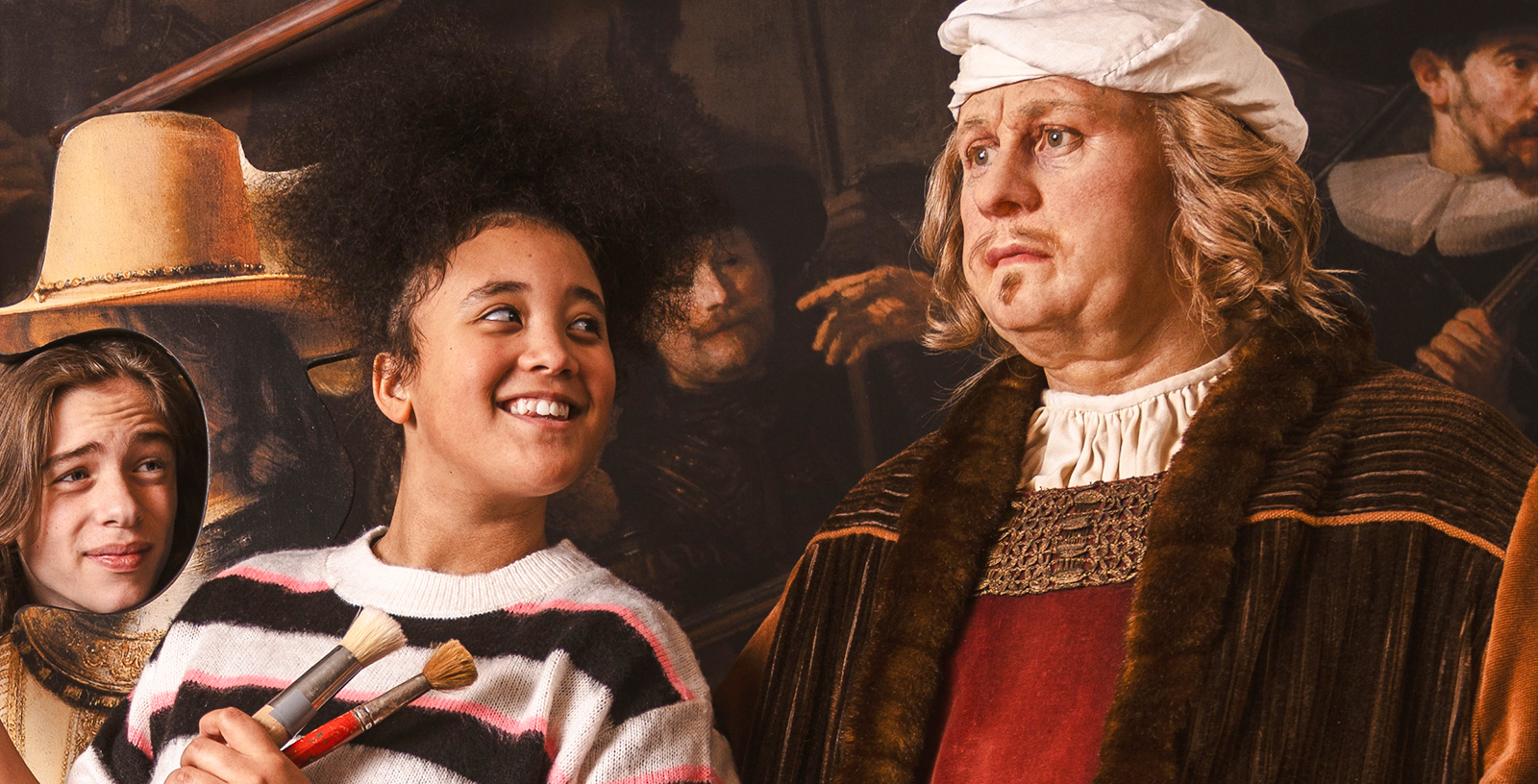 Visitors interacting with Rembrandt wax figure at Madame Tussauds Amsterdam.