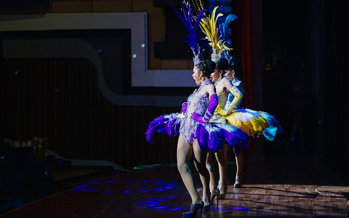 Performers in colorful costumes on stage at Alcazar Cabaret Show, Pattaya.