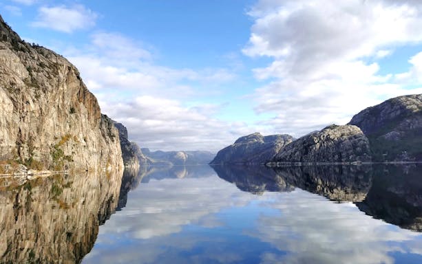 Lysefjord cliffs reflecting in calm water during Stavanger cruise.