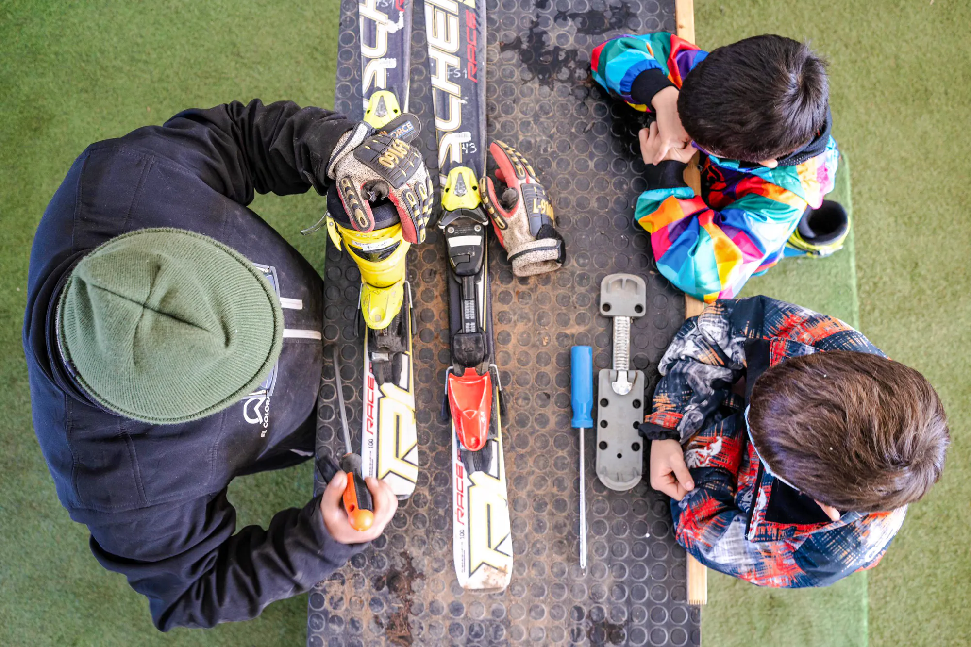 Ski instructor adjusting equipment with children at El Colorado Ski, Santiago.