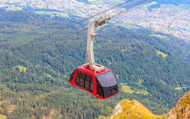 Cable car ascending Mount Pilatus with Lucerne landscape below.