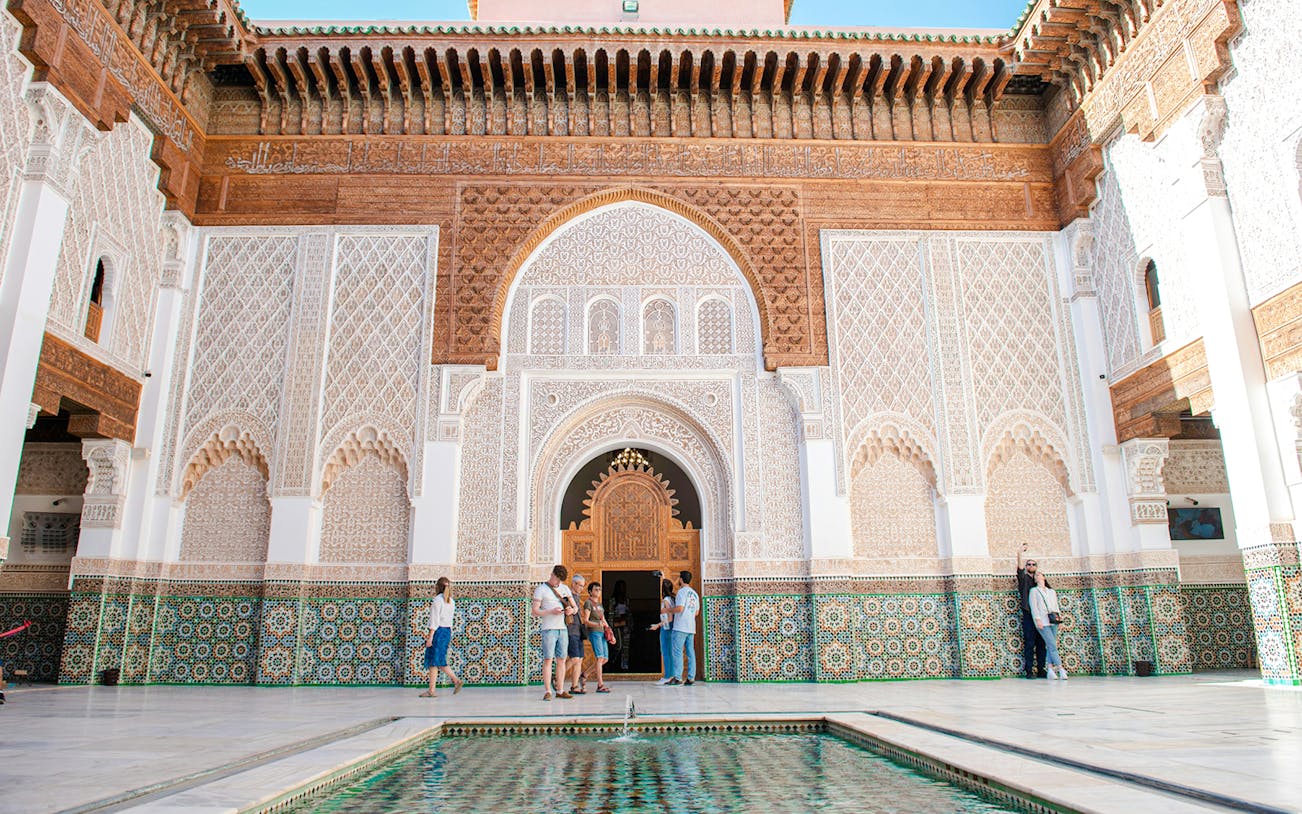 Madrasa Ben Youssef courtyard with intricate tilework and carved arches, Marrakech.
