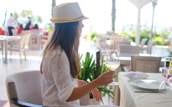 Woman enjoying wine at an indoor restaurant in Albania.