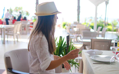 Woman enjoying wine at an indoor restaurant in Albania.