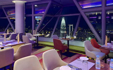 Skyline view from Orbit Revolving Restaurant in KL Tower, Kuala Lumpur, with city lights.