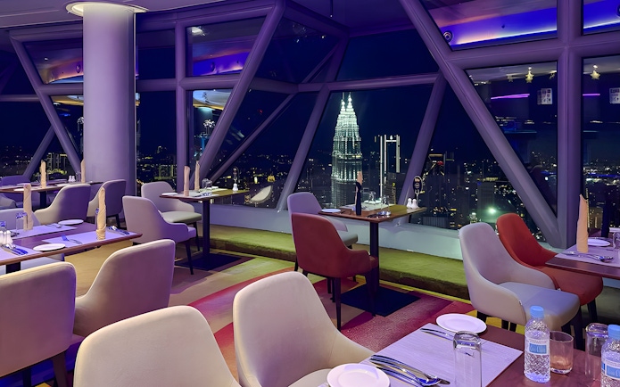 Skyline view from Orbit Revolving Restaurant in KL Tower, Kuala Lumpur, with city lights.
