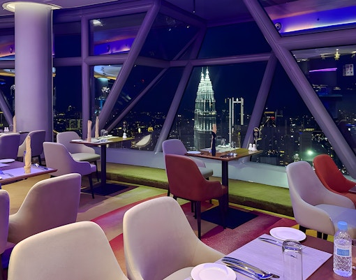 Skyline view from Orbit Revolving Restaurant in KL Tower, Kuala Lumpur, with city lights.
