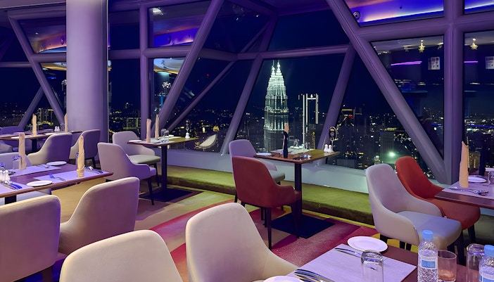Skyline view from Orbit Revolving Restaurant in KL Tower, Kuala Lumpur, with city lights.