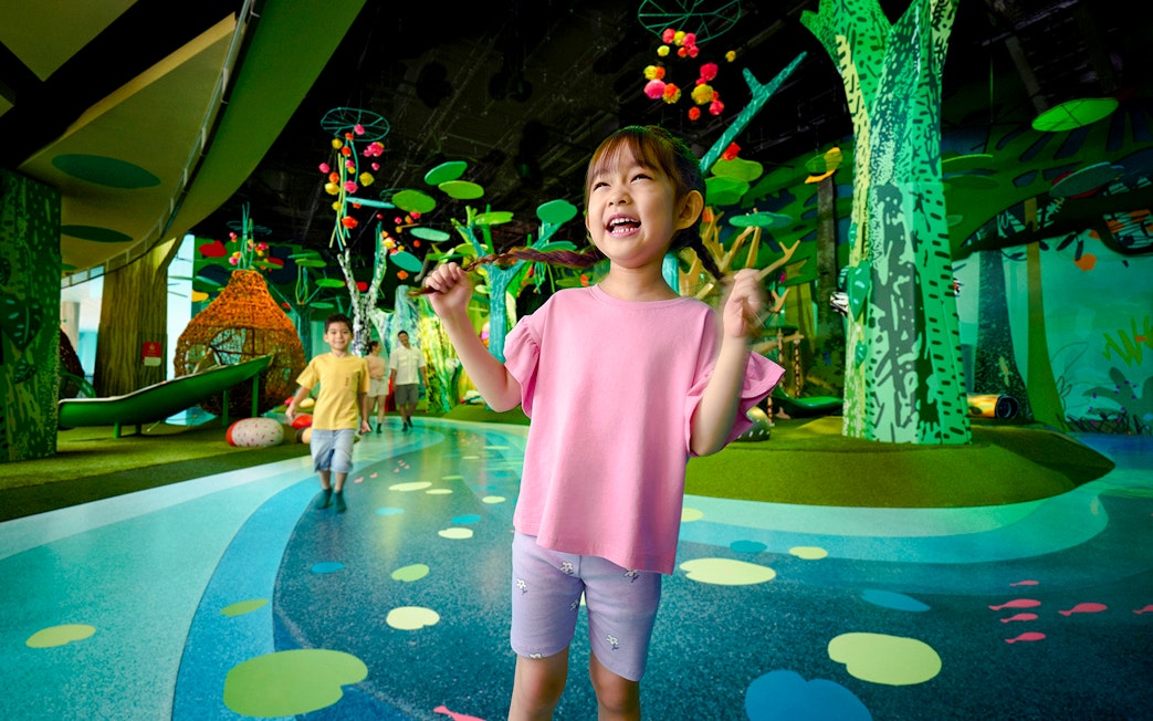 Children playing at Curiosity Cove Main Entrance with colorful indoor playground.