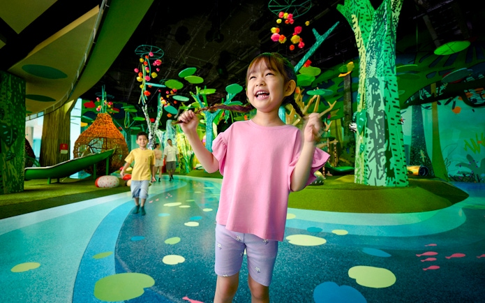 Children playing at Curiosity Cove Main Entrance with colorful indoor playground.