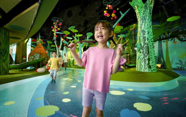 Children playing at Curiosity Cove Main Entrance with colorful indoor playground.