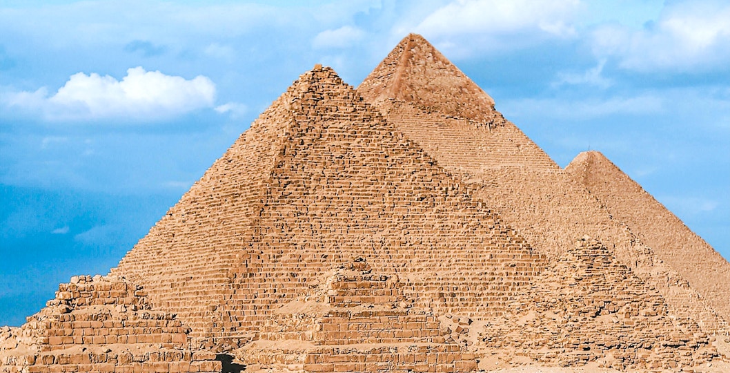 Pyramids of Giza under a blue sky in Egypt.