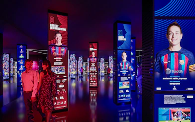 FC Barcelona museum exhibit with digital displays of players, part of immersive tour experience.