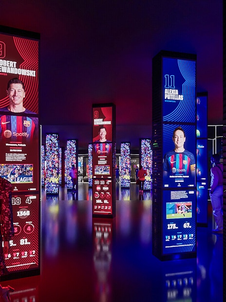 FC Barcelona museum exhibit with digital displays of players, part of immersive tour experience.