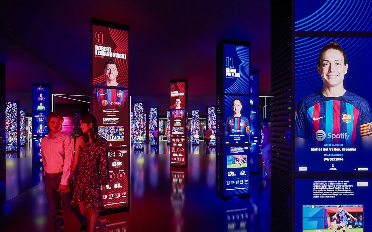 FC Barcelona museum exhibit with digital displays of players, part of immersive tour experience.