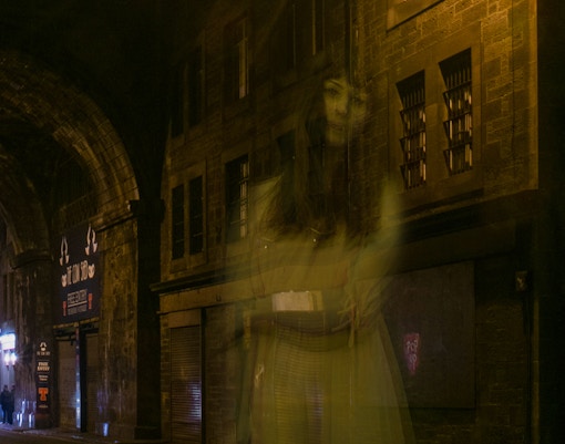 Ghostly figure in a dimly lit alley during Extreme Paranormal Activity Tour.