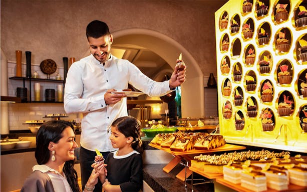 Family enjoying dessert at Atlantis the Palm buffet near Ambassador Lagoon Aquarium.
