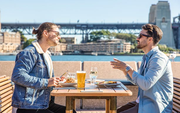 Dining with view of Sydney Harbour Bridge during guided Opera House tour.