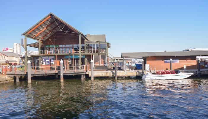 Barrack Street Jetty Terminal with docked tour boats in Perth, Australia.