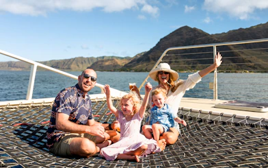 Family enjoying a whale watching sail on a catamaran in West Oahu.