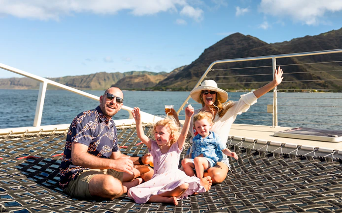 Family enjoying a whale watching sail on a catamaran in West Oahu.