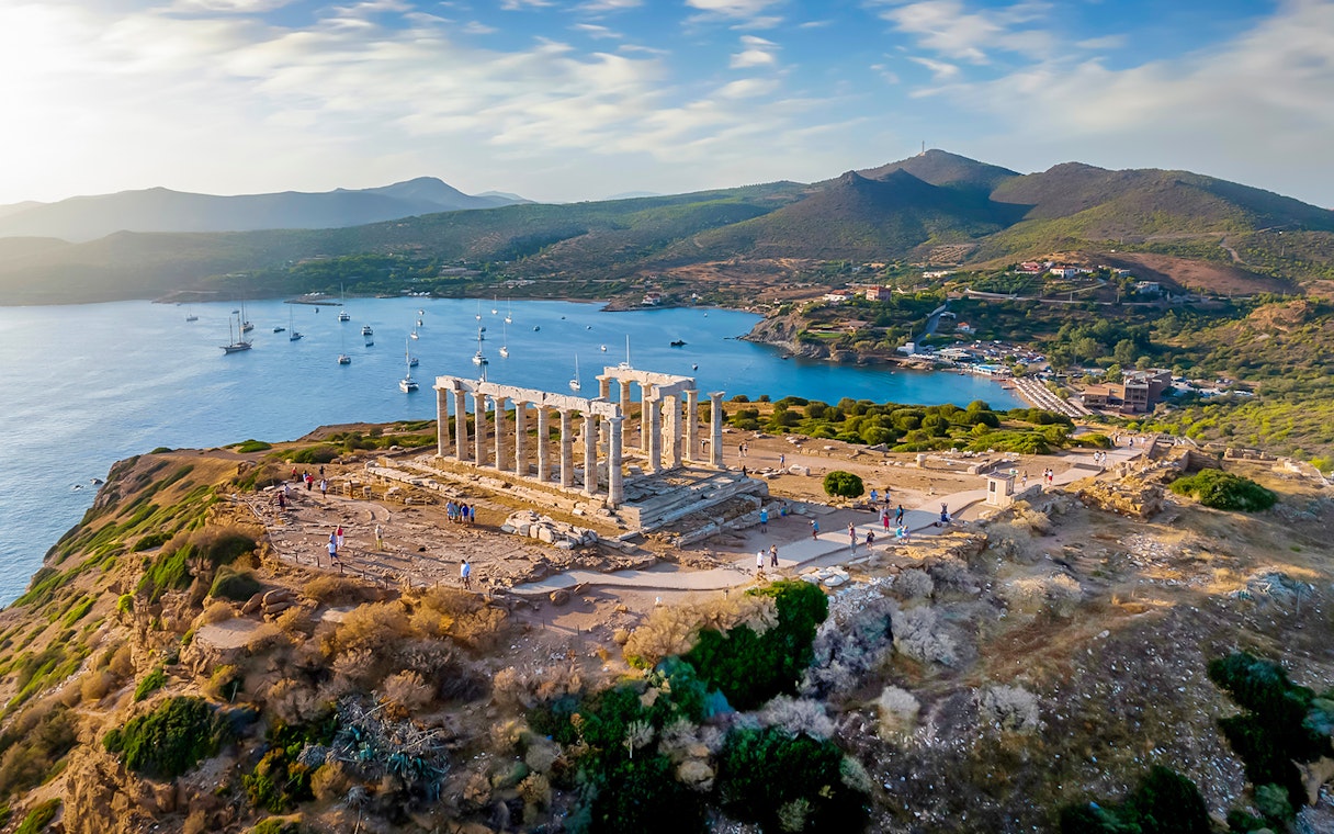 Temple of Poseidon at Cape Sounion overlooking the sea during sunset.
