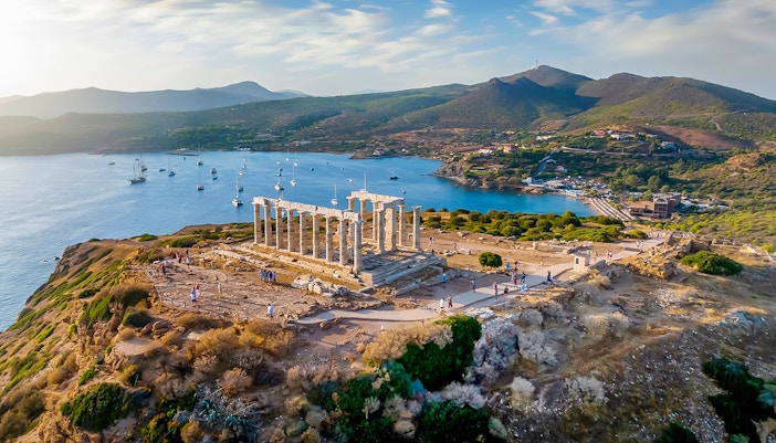 Cape Sounion Temple of Poseidon silhouetted against a vibrant sunset sky.
