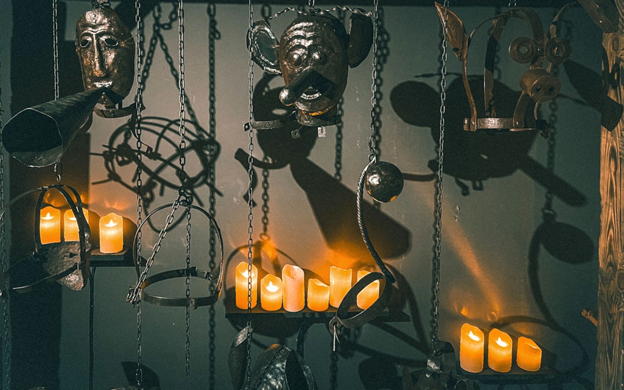 Medieval torture devices and candles at the Medieval Torture Museum exhibit.