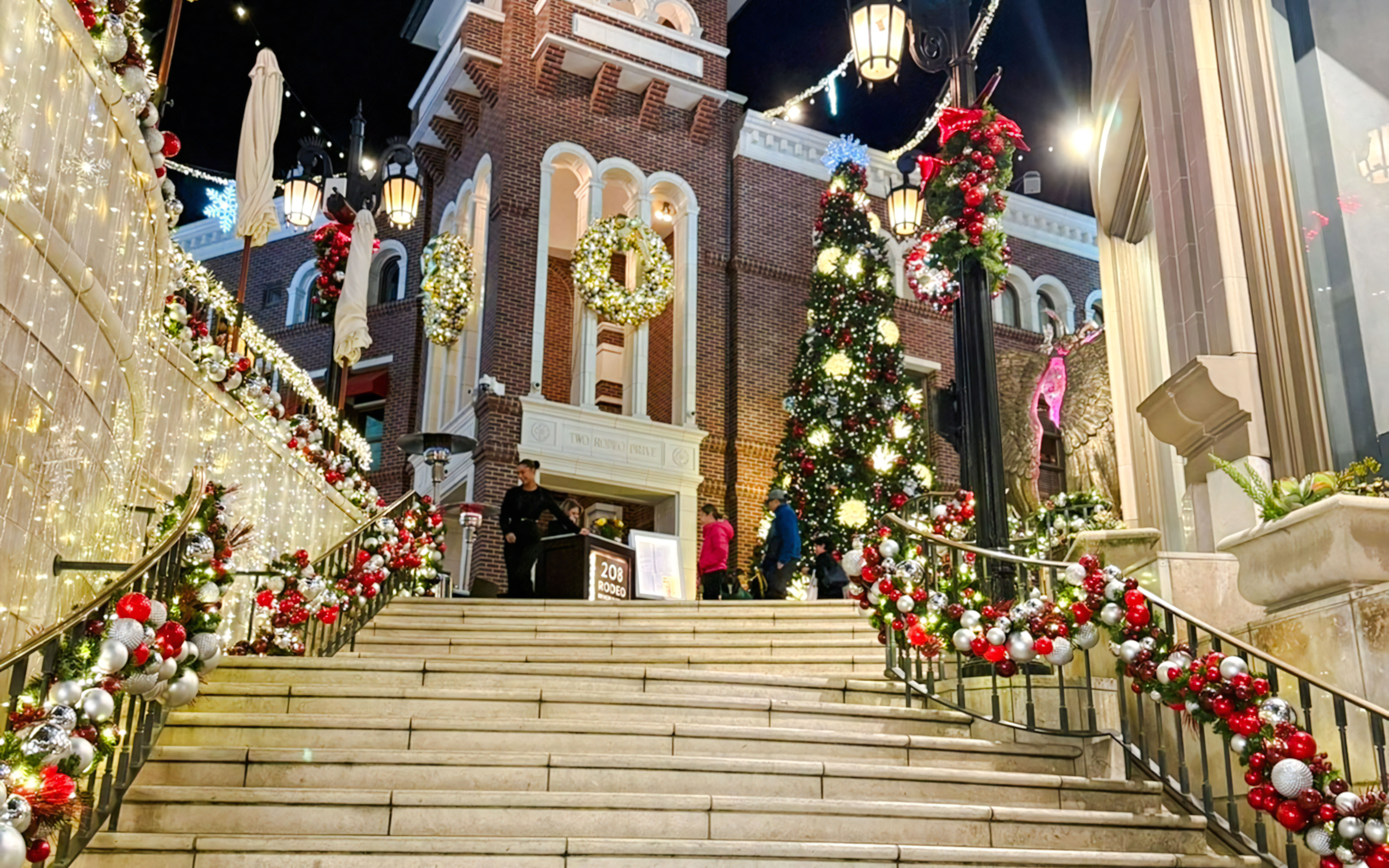 Festive Christmas decorations at The Grove, featuring a large tree and illuminated garlands on stairs.