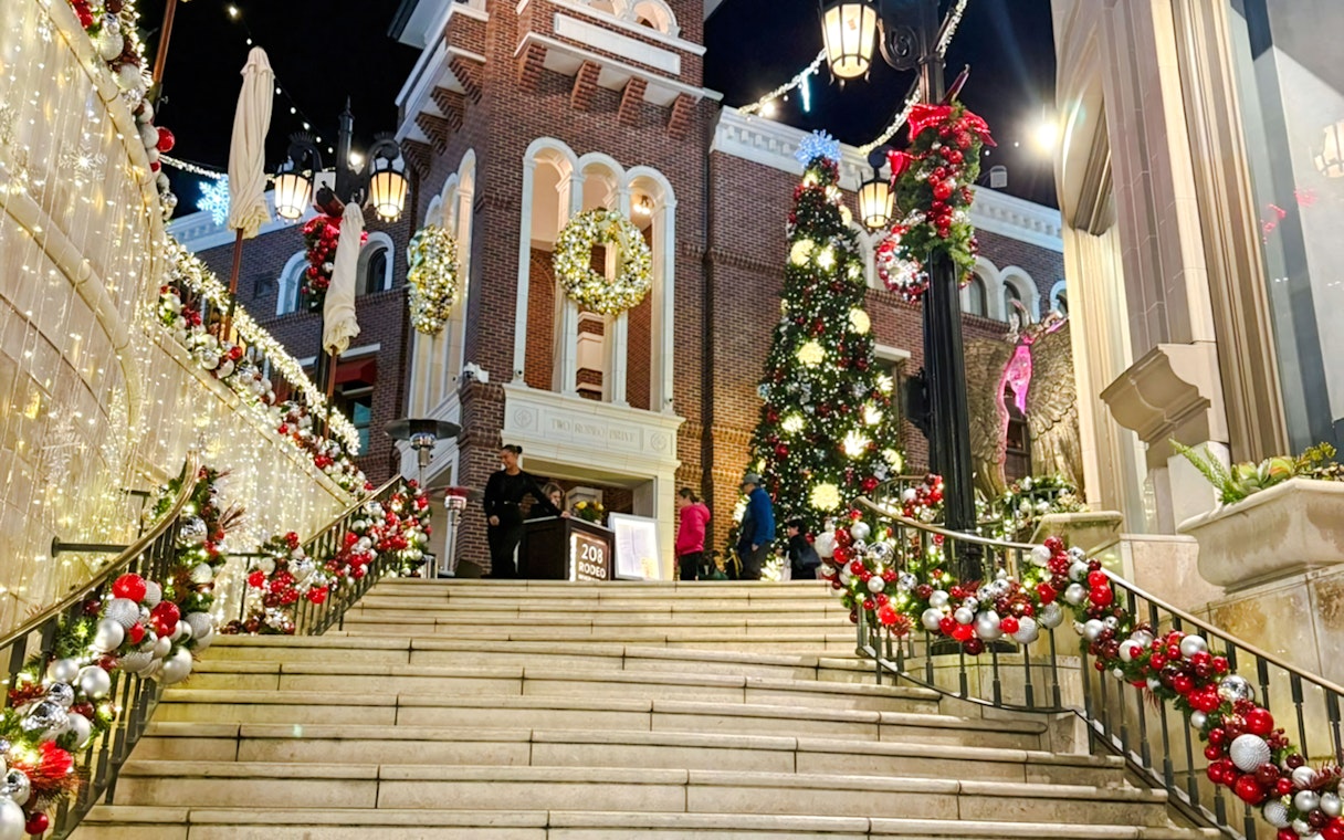 Festive Christmas decorations at The Grove, featuring a large tree and illuminated garlands on stairs.