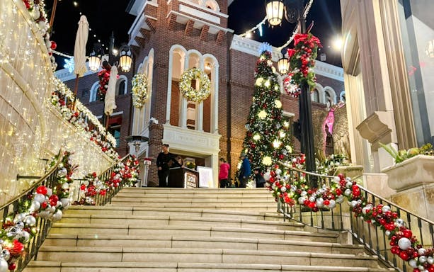 Festive Christmas decorations at The Grove, featuring a large tree and illuminated garlands on stairs.