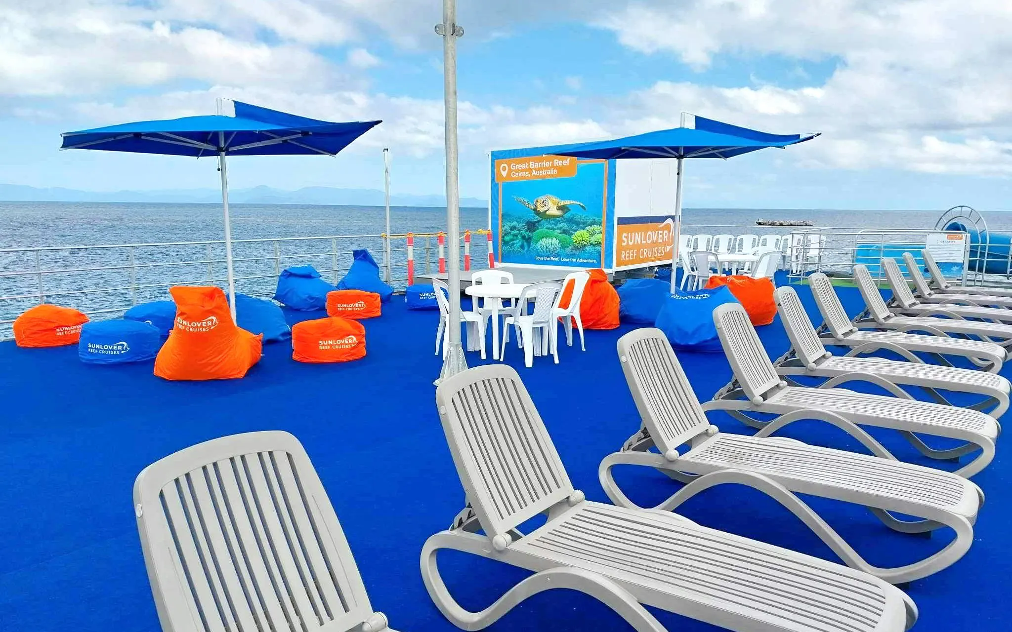Sunlover Reef Cruises deck with lounge chairs and bean bags, Great Barrier Reef backdrop.