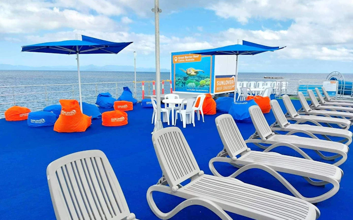 Sunlover Reef Cruises deck with lounge chairs and bean bags, Great Barrier Reef backdrop.