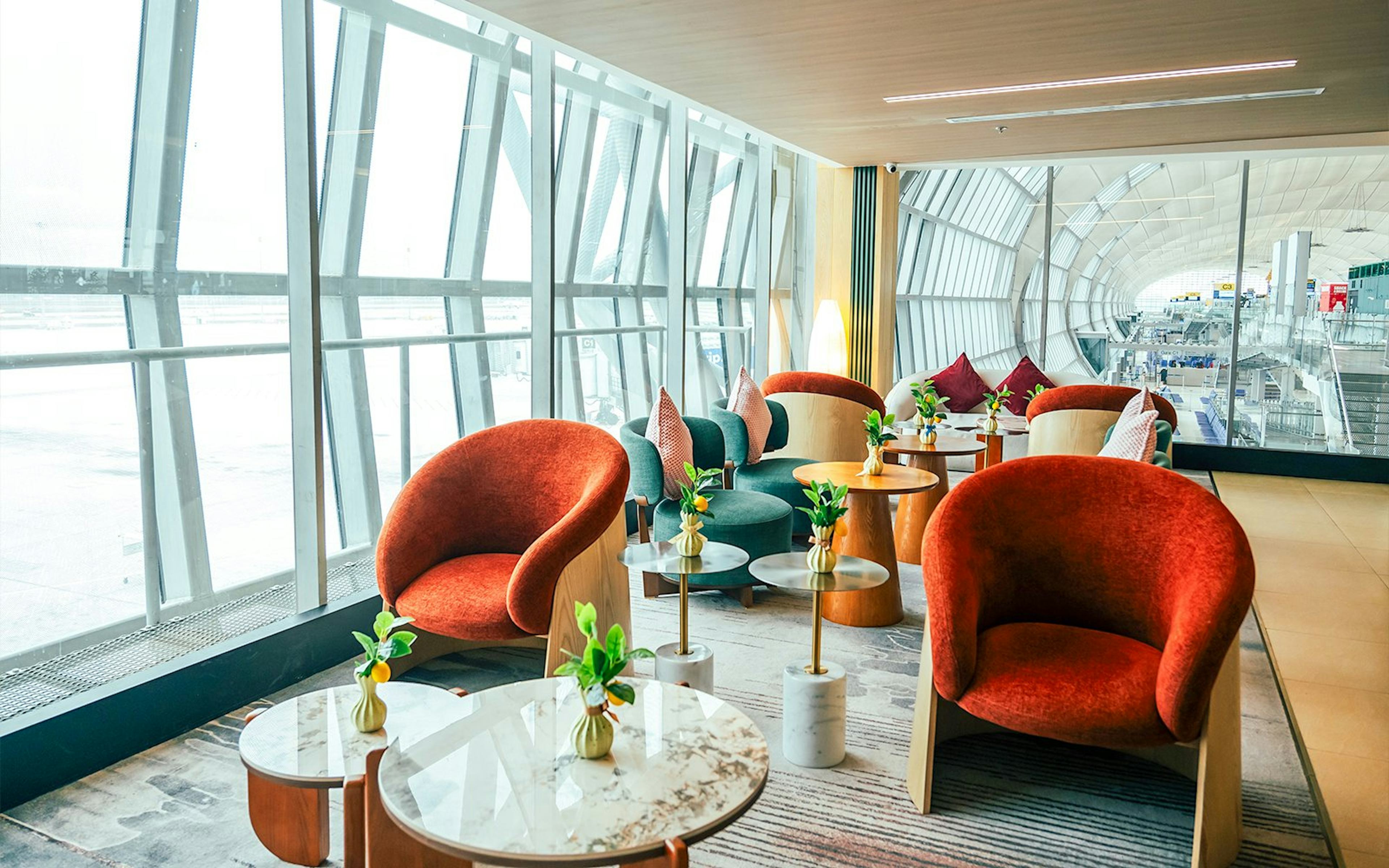 Coral Airport Lounge seating area at Suvarnabhumi Airport with modern chairs and tables.