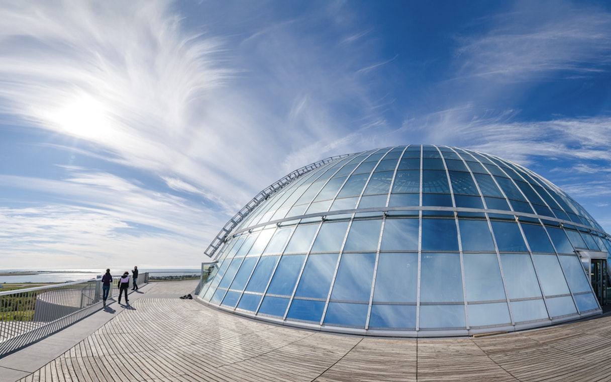 Perlan Museum's glass dome with visitors on the 360-degree observation deck in Reykjavik.