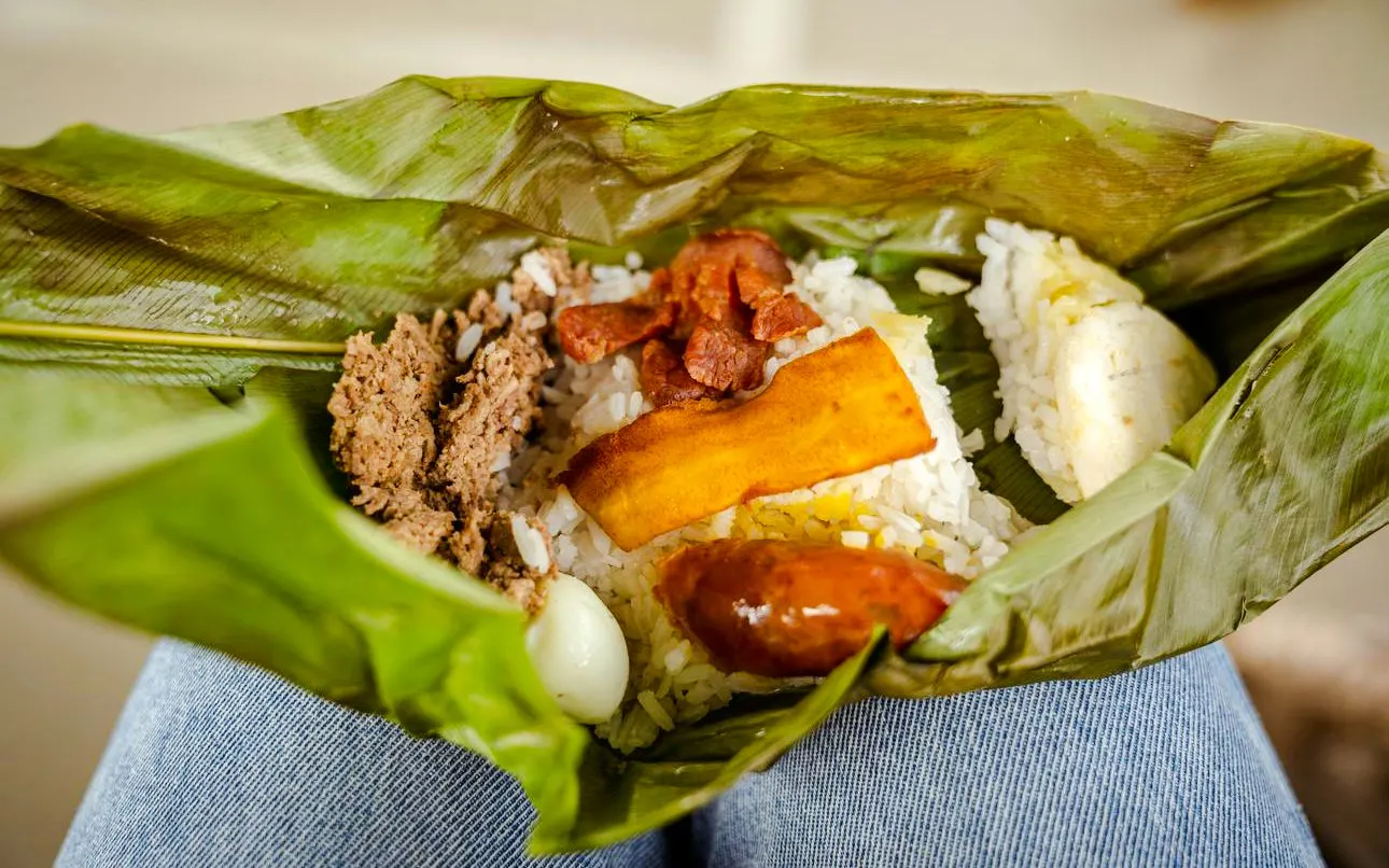 Fiambre Antioqueño with rice, plantain, meat, and sausage wrapped in banana leaves.