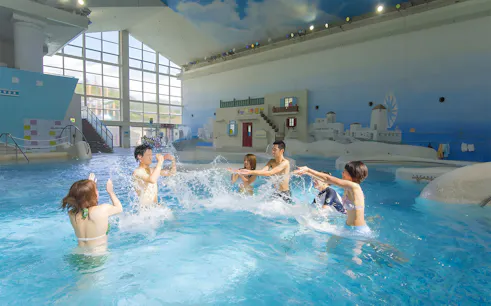 Visitors enjoying indoor pool at Hakone Kowakien Yunessun Hot Spring, Japan.