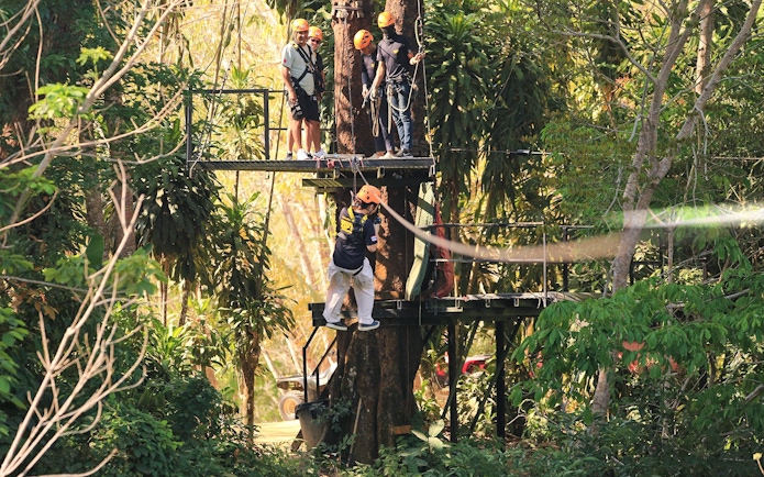 Participants preparing for a zipline adventure in the lush forest of Phuket Paradise.