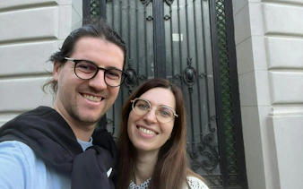 Couple in front of ornate iron gate during Haunted Bucharest city exploration game.