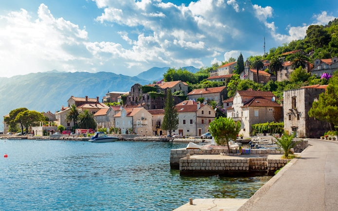 Perast town waterfront with historic stone buildings and mountains in Montenegro.